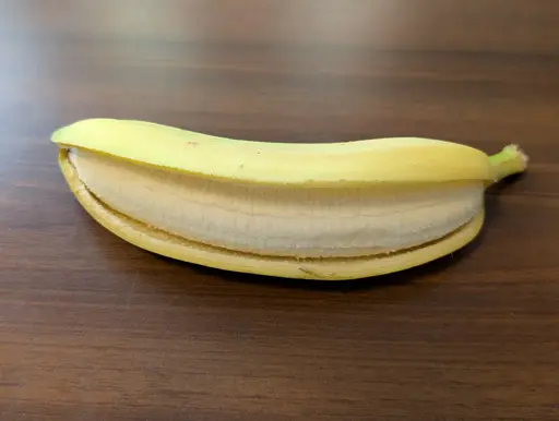 Banana, opened lengthwise and lying in its peel