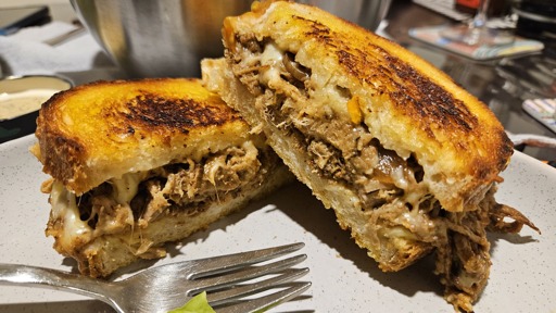 toasted girello (top round) and cheese toastie, one piece leaning on the other at 90 degrees on a stone plate. 